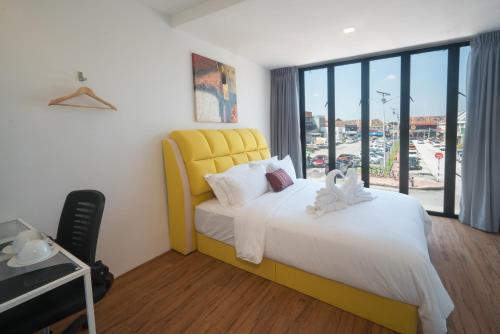 梳邦再也我的Sj酒店 的一间卧室设有一张黄色的床和一个大窗户