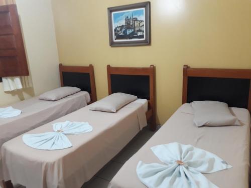 三玛丽亚镇Pousada Rural Veredas的一间设有两张带白色床单的床的房间