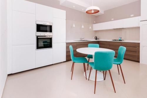 孔韦尔萨诺Alchimia Apartment的厨房配有白色橱柜和桌椅
