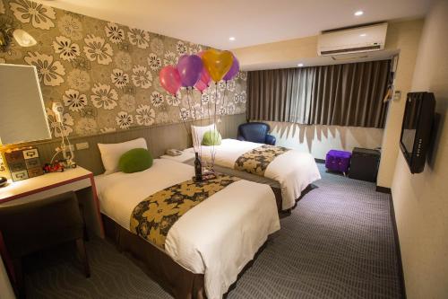 台北Hotel Zoo的酒店客房的墙上设有两张带气球的床。