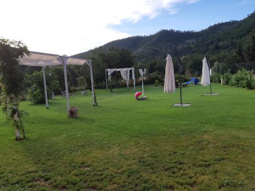 PállareB&B Le Stanze del Moro的草地上的一个公园,里面放着雨伞和球