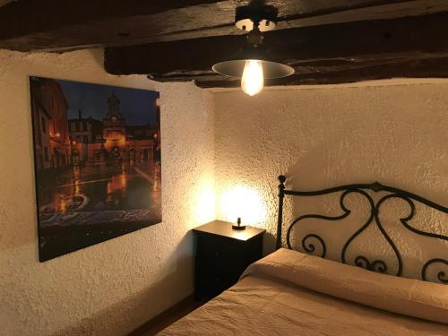 苏特里La Casetta ai Lavatoi di Sutri的一间卧室配有一张带灯和照片的床