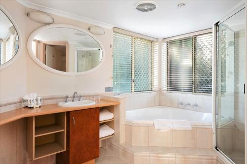 卡尔古利卡尔古利耶尔维顿探索服务公寓式酒店的带浴缸、水槽和镜子的浴室