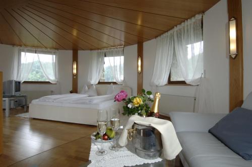 德意志兰茨贝格伯格德意志兰茨贝格酒店的卧室配有一张白色的大床和一张沙发。