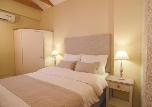 卢布尔雅那Janez Rooms的一间卧室配有一张带两盏灯的大型白色床。