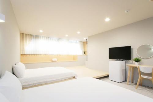 台北Place Inn Taipei的一间卧室配有两张床和一台平面电视