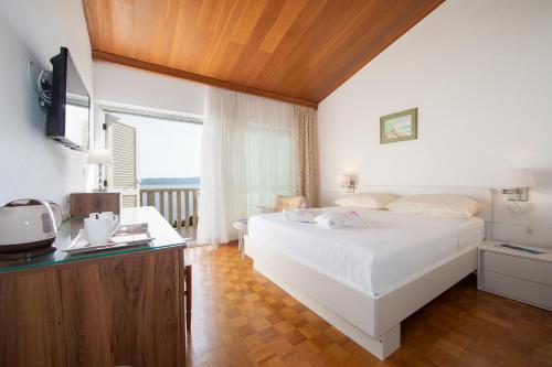 布雷拉Apartmens Villa Antonio 88的卧室配有白色的床和电视。