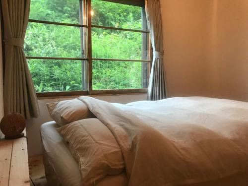 岩见泽市NORD house的一间卧室设有一张床和一个大窗户