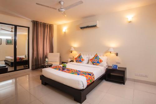 新德里沙克德阿努坦法布酒店的一间卧室,卧室内配有一张大床
