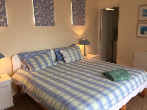 威特桑德Breede View Holiday Home的一间卧室配有一张带蓝白色 ⁇ 面毯的床