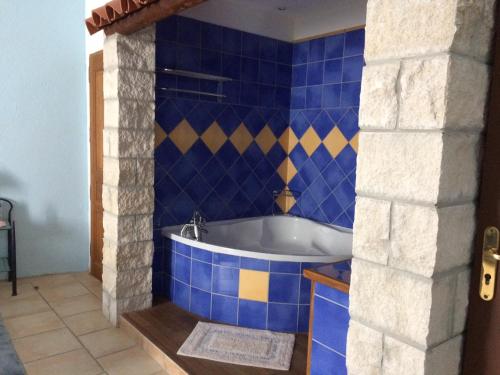 Berrias Et Casteljau拉麦斯安格旅馆的蓝色瓷砖浴室设有浴缸。