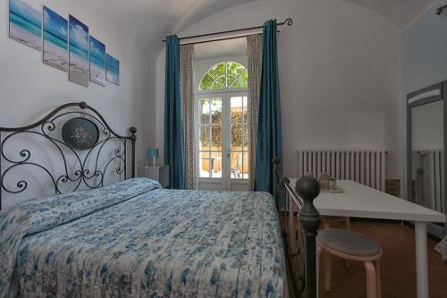 比萨Magnolia Comfort & Rooms的一间卧室配有一张床、一张桌子和一个窗户。