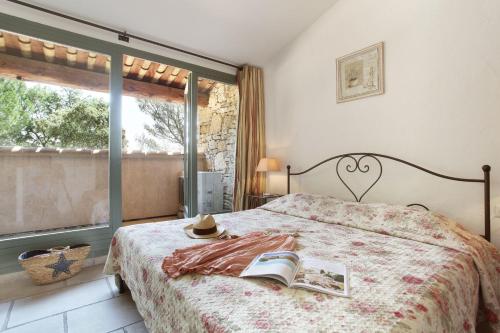 戈尔德Résidence Prestige Odalys La Bastide des Chênes的一间卧室配有一张带书本的床和窗户