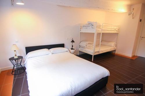 桑坦德Enjoy Santander的卧室配有白色的床和双层床。
