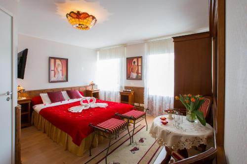 派尔努伊登别墅酒店的一间卧室配有红色的床和桌椅
