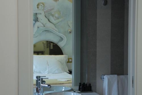 托莱多Grecorooms的浴室设有镜子、水槽和床