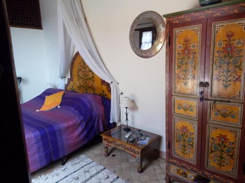 非斯乐特池娜摩洛哥传统庭院住宅的一间卧室配有一张床、梳妆台和桌子