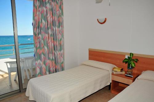 波蒂纳茨萨雷纳尔公寓酒店的一间带两张床的卧室和一个海景阳台