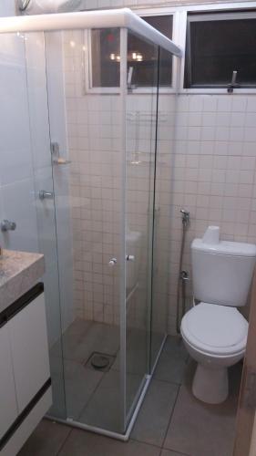 瓜拉派瑞Apartamento Ed. Ouro Preto Praia do Morro的浴室设有玻璃淋浴间和卫生间