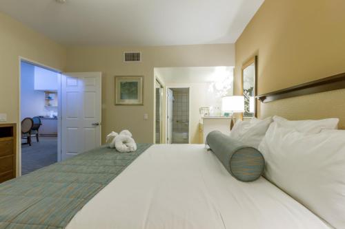 卡尔斯巴德Grand Pacific Palisades Resort的一张白色的大床,上面有一只填充的动物