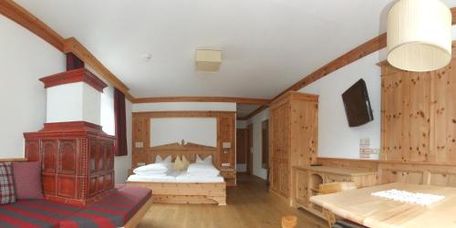 迈尔霍芬加尼奥伯梅尔酒店的一间带两张床铺的卧室,位于带木墙的房间内
