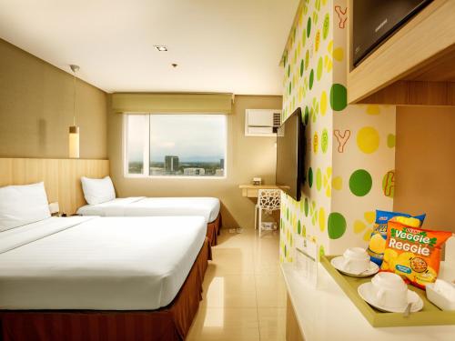 伊洛伊洛Injap Tower Hotel的酒店客房设有两张床和窗户。
