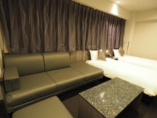 东京羽田旅馆的酒店客房,设有两张床和一张沙发