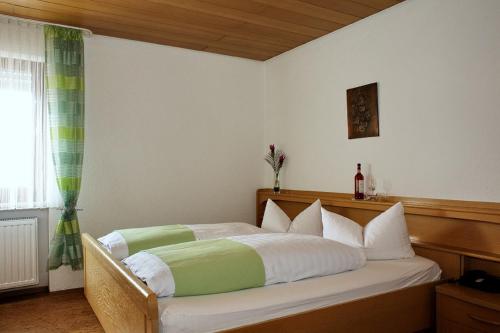 SandWeinhotel Goger的一间卧室配有一张铺有白色和绿色床单的床