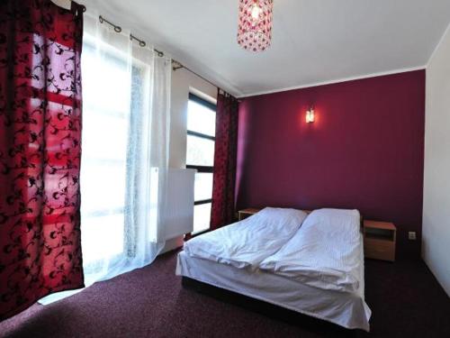 切哈诺维茨Hotel Arkadia的一间卧室配有一张床和紫色的墙壁
