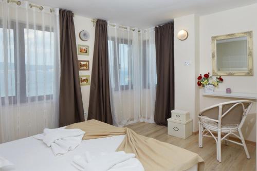 内塞伯尔Villa Elea的一间卧室配有一张床、一把椅子和窗户。