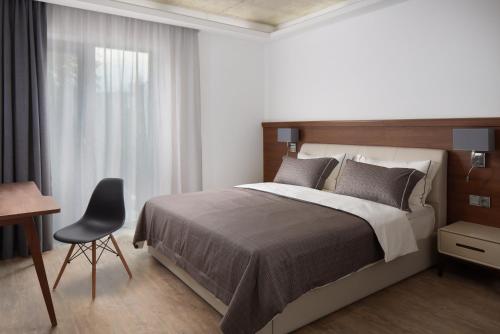 伏尔塔瓦河畔利普诺JBX Resort Apartments Lipno的一间卧室配有一张床、一张桌子和一把椅子