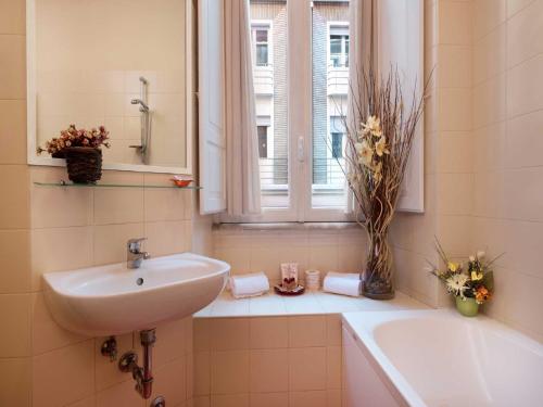 罗马多米兹伊诺奥酒店的一间带水槽和浴缸的浴室以及窗户。
