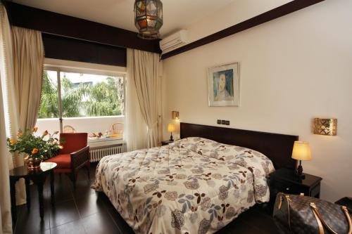 丹吉尔夏拉酒店 的卧室配有床、椅子和窗户。