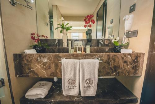 贝鲁特Louis V Hotel Beirut的浴室设有水槽和台面上的毛巾