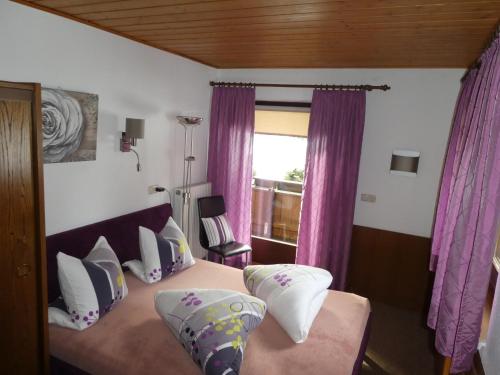 德弗雷根谷地圣雅各布Almblick Appartements的一间卧室配有一张带紫色窗帘的床和窗户。