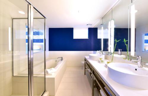 迈阿密海滩佩斯塔纳南滩酒店的一间带两个水槽和玻璃淋浴间的浴室