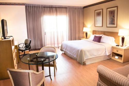维多利亚城维多利亚城爱住酒店的酒店客房设有一张床铺和一张玻璃桌