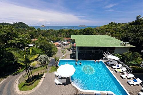 曼努埃尔安东尼奥El Faro Containers Beach Hotel的一个带游泳池和椅子的度假胜地和一座建筑
