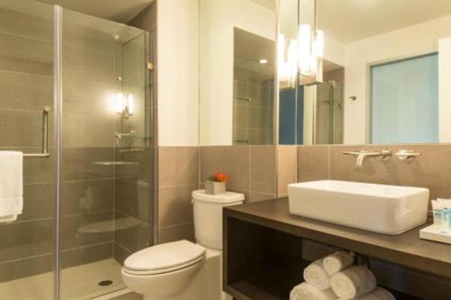 加尔维斯敦海港码头之家酒店的浴室配有卫生间、盥洗盆和淋浴。