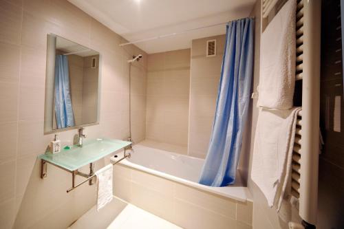 瓦伦西亚里尔码头出租公寓的一间带水槽、浴缸和镜子的浴室