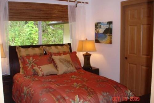 HaikuBamboo Valley Inn的一间卧室设有红色的床和窗户。