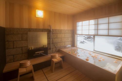 金泽山尾旅馆的带浴缸的浴室和窗户。