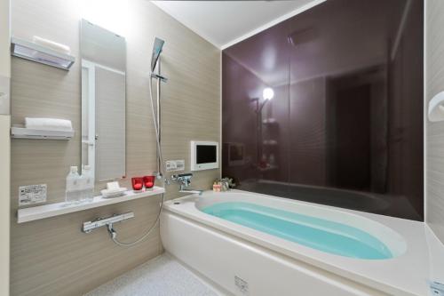 横滨HOTEL ROY(Adult Only)的带浴缸和水槽的浴室以及电视。