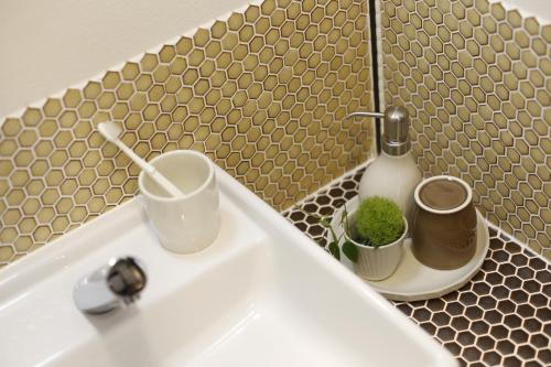 富士河口湖金雅富士河口湖酒店的浴室水槽,内有一瓶肥皂和植物
