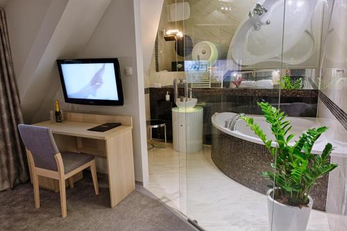 Górzno博雅德克酒店的带浴缸、电视和书桌的浴室
