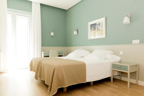 萨拉戈萨索斯酒店的卧室配有一张带白色床单和枕头的大床。