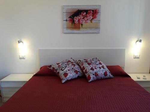 波萨达Affittacamere b&b Il FIORE的一间卧室配有红色的床和两个枕头