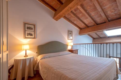波普洛尼亚Poggio all'Agnello Sport & Active Holidays的一间卧室配有一张床和一张带台灯的桌子