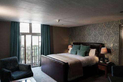 剑桥温恩德比斯特剑桥酒店的卧室配有床、椅子和窗户。