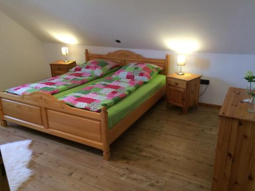 凯沃拉尔Ferienwohnung Niederrhein-Oase的一间卧室配有木床和2个床头柜